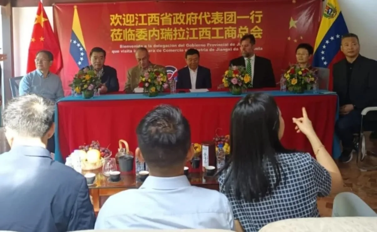 Delegaciones de China y Venezuela reunidas en una mesa de honor durante un encuentro bilateral de comercio.