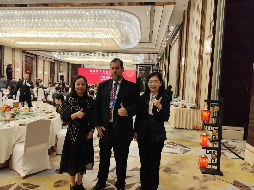 Tres delegados de AVEACHI posan sonrientes en el salón de gala del VI Foro de Amistad China–América Latina en Xi'an.