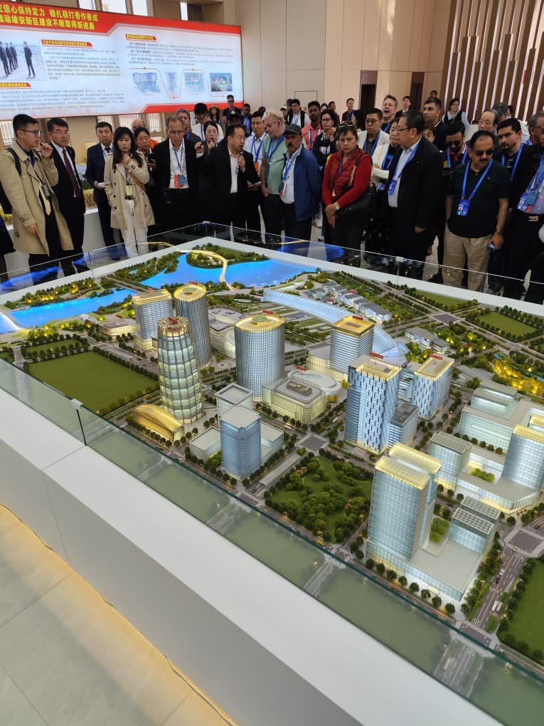 Delegación internacional observa la maqueta de una nueva ciudad futurista china.
